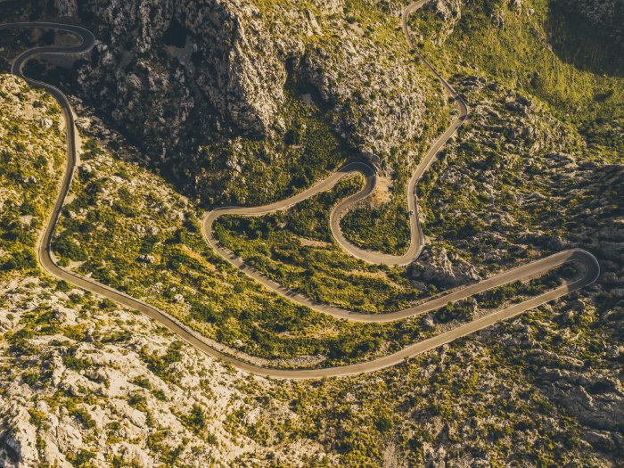 A curvy road with switchbacks winds its way through the desert mountains.