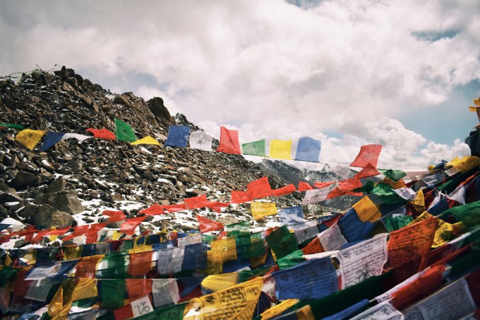 Strings of prayer flags above the rocks at a climbing base camp in the Himalayas.
