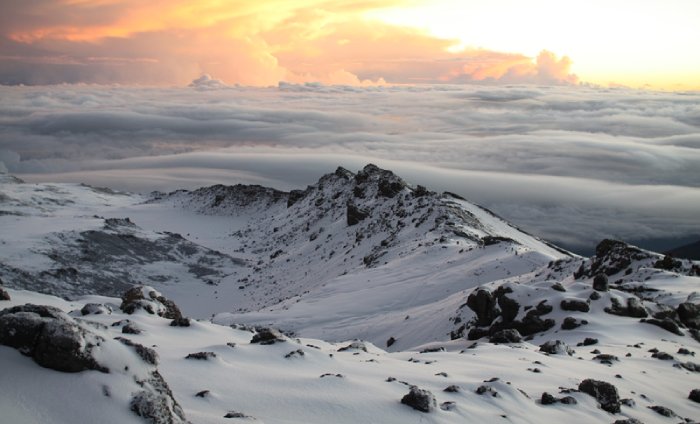 Una cumbre nevada del Monte Kilimanjaro por encima de las nubes.