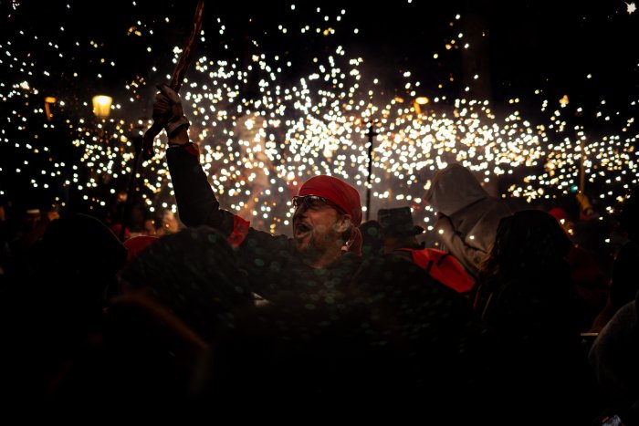 A man wearing a red bandana holds a sparkler with several others in celebration.