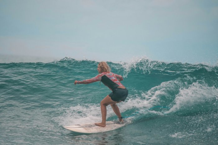 A middle-aged woman surfing on a right-hand break.