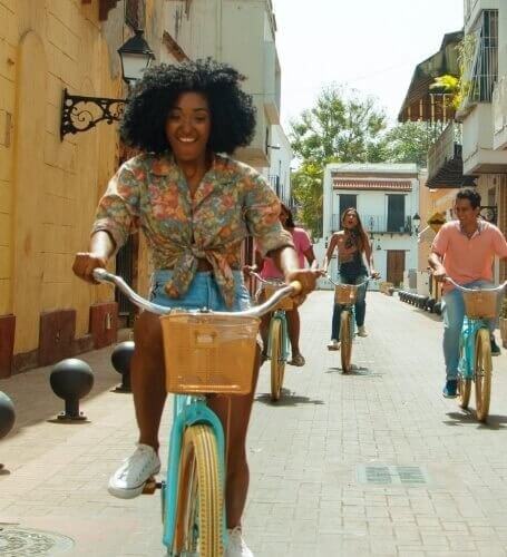 group of friends biking down street in South America