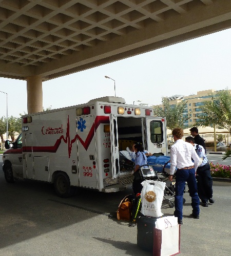 An ambulance arrives at an emergency room as paramedics begin to transport the patient inside.