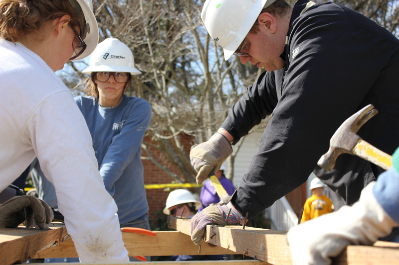 group of volunteer construction workers building framing