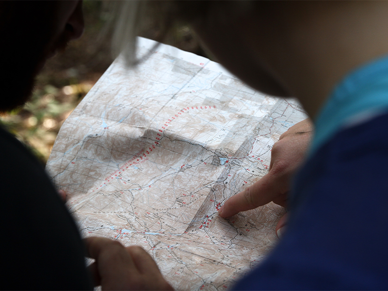 two people looking at map one pointing to desination
