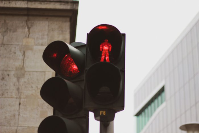 A red traffic light and red pedestrian crossing light in a city.