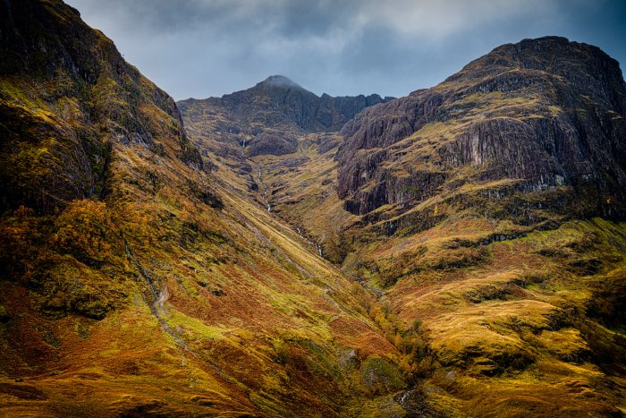 A grassy canyon between two peaks in the Scottish Munro Mountains.