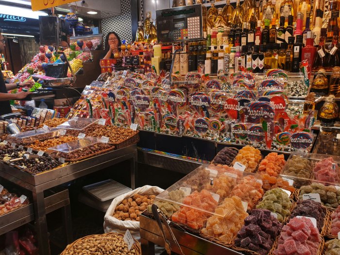 The interior of a small market in Barcelona packed with colorful treats.